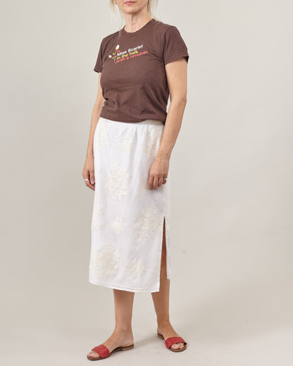 women wearing a white midi skirt with side slit and a brown t-shirt plus red sandlas